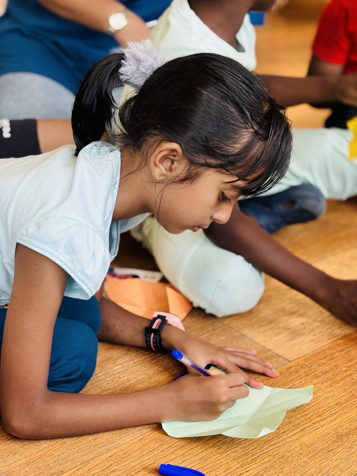 A young girl focused on writing