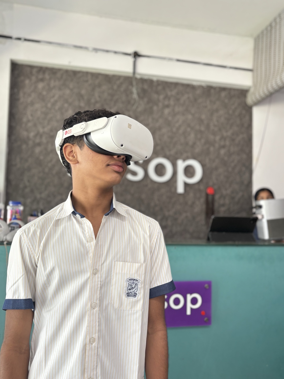 A Learning Pod student in white school uniform exploring a virtual world through a VR headset