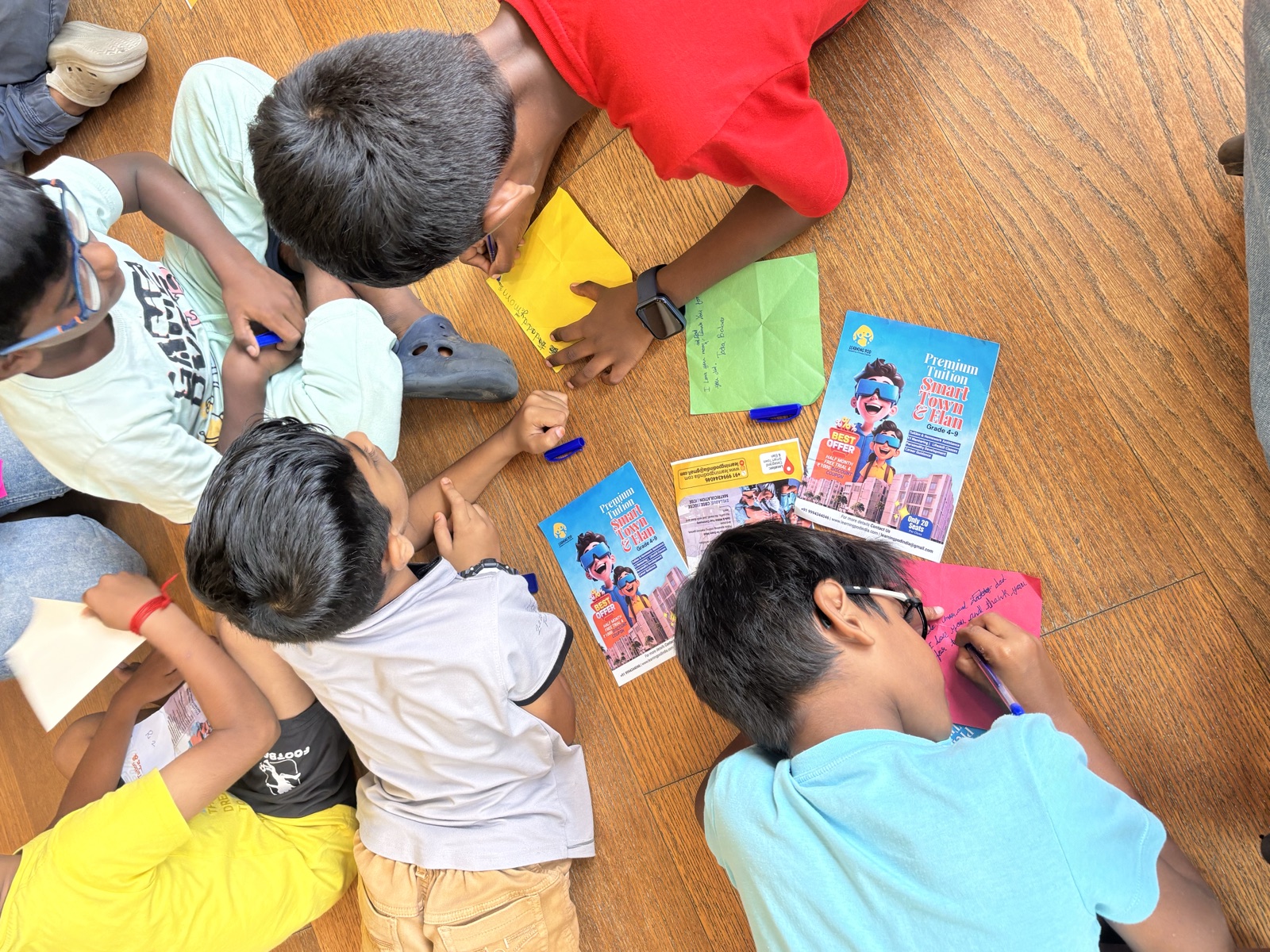 Kids writing together on the classroom floor