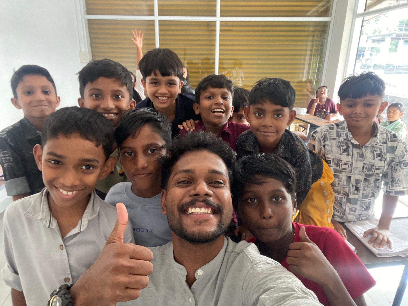 A tutor's selfie with young Learning Pod students